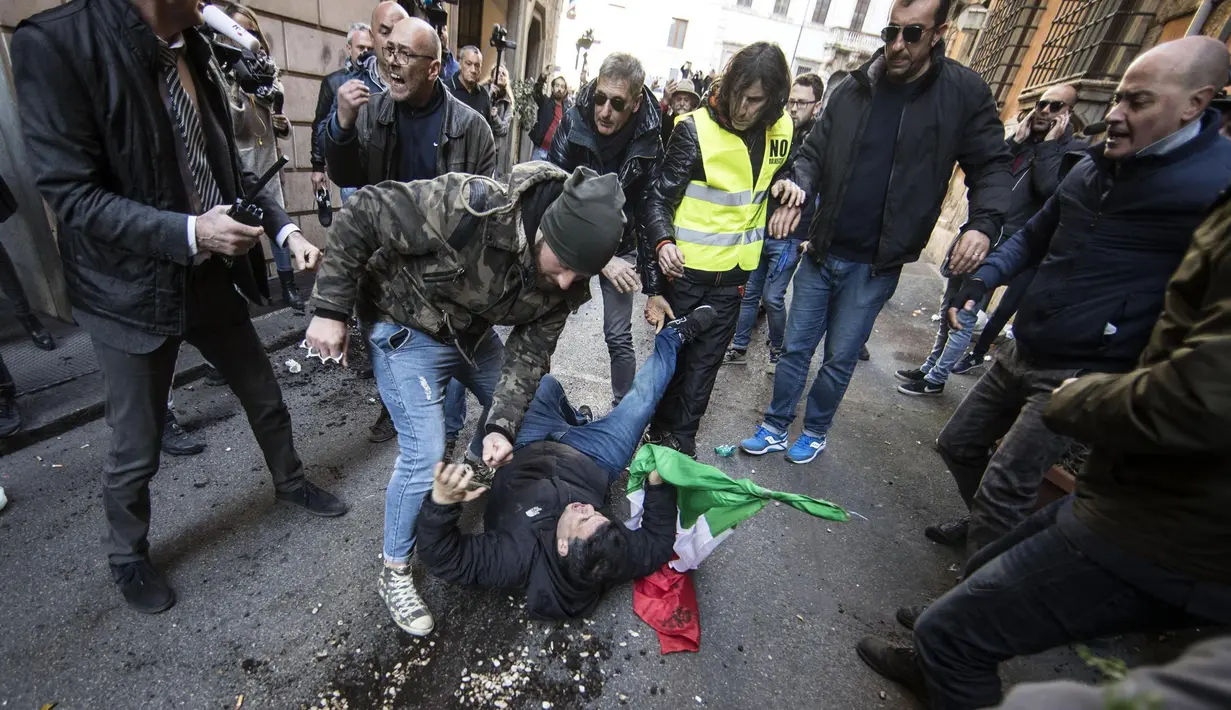Seorang lelaki terjatuh saat berunjuk rasa di Roma, Italia, Selasa (21/2). Para pengemudi mengaku tersaingi oleh keberadaan Uber. (AP Photo / Alessandra Tarantino)