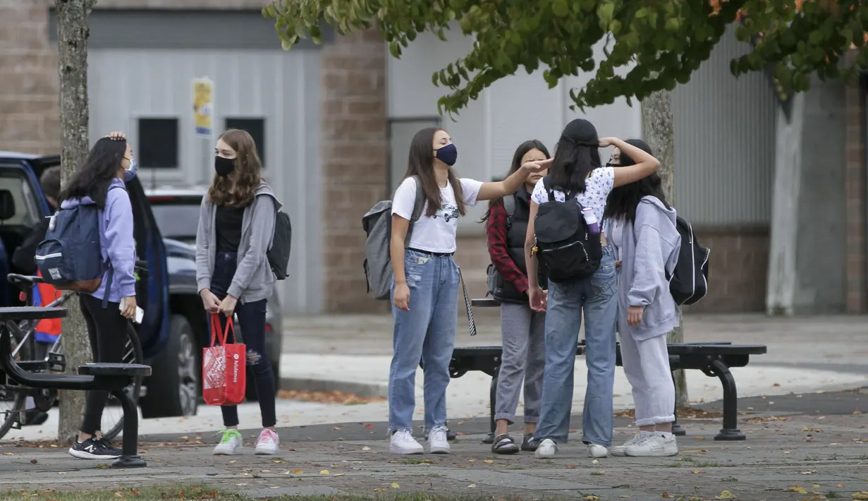 Para siswa yang mengenakan masker terlihat di sebuah sekolah di Vancouver, British Columbia, Kanada, 21 September 2020. Paparan COVID-19 telah dilaporkan di sedikitnya 20 sekolah di British Columbia sejak para siswa kembali belajar di sekolah dua pekan lalu. (Xinhua/Liang Sen)