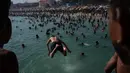 Anak-anak melompat untuk berenang di pantai Macumba. (Tercio Teixeira/AFP)