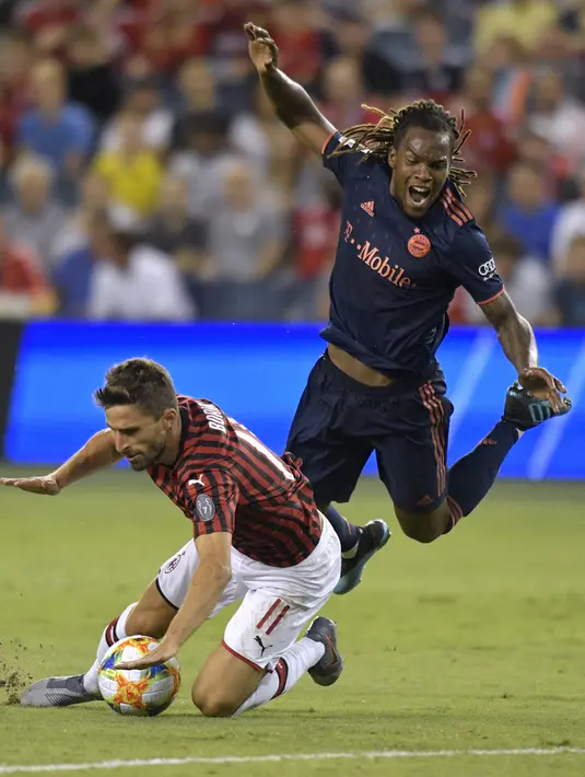 Penyerang AC Milan, Fabio Borini saat melanggar gelandang Bayern Munchen, Renato Sanches  selama pertandingan International Champions Cup 2019 di Kansas City, Amerika Serikat (24/7/2019). AC Milan kalah tipis 1-0 atas Munchen berkat gol Leon Goretzka. (AFP Photo/Tim Vizer)