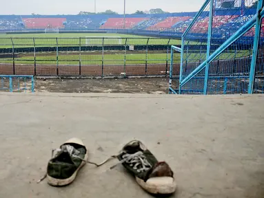 Sepasang sepatu terlihat di tribun Stadion Kanjuruhan setelah tragedi kerusuhan pada pertandingan sepak bola antara Arema Vs Persebaya di Malang, Jawa Timur, Minggu (2/10/2022). Dunia sepak bola Indonesia kembali berduka menyusul terjadinya kerusuhan pascapertandingan Arema vs Persebaya. (AP Photo/Hendra Permana)