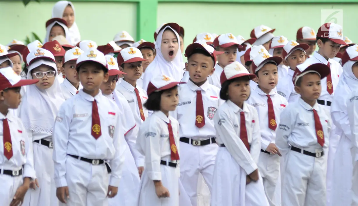 Seorang murid menguap diantara rekannya di sela upacara bendera di SDN Jatinegara Kaum 15 Pagi, Jakarta, Senin (15/7/2019). Sebanyak 32 anak menjadi murid baru SDN tersebut pada hari pertama masuk sekolah tahun ajaran 2019/2020. (merdeka.com/Iqbal S Nugroho)