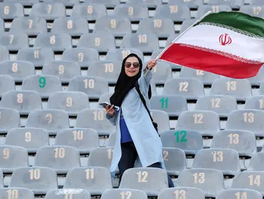 Wanita Iran mengibarkan bendera negaranya saat akan menyaksikan laga kualifikasi Piala Dunia 2022 antara Iran dengan Kamboja di Stadion Azadi, Teheran, Iran, Kamis (10/10/2019). Wanita Iran akhirnya diizinkan menonton bola dalam stadion setelah 38 tahun dilarang. (AP Photo/Vahid Salemi)