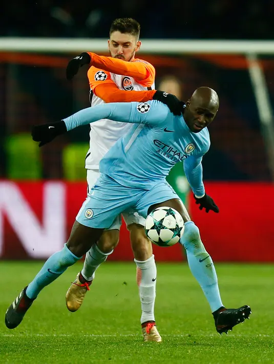 Pemain Manchester City, Eliaquim Mangala berebut bola dengan pemain Shakhtar Donetsk, Facundo Ferreyra pada matchday terakhir Grup F Liga Champions di Stadion Oblasny Sport Komplex Metalist, Kamis (7/12). Manchester City takluk 1-2. (AP / Efrem Lukatsky)