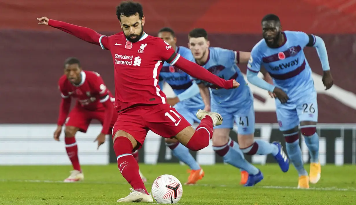 Penyerang Liverpool, Mohamed Salah, melepaskan tendangan penalti saat melawan West Ham United pada laga Liga Inggris di Stadion Anfield,  Minggu (1/11/2020). Liverpool menang dengan skor 2-1. (AP Photo/Jon Super, Pool)