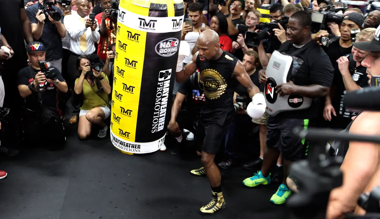 Petinju Floyd Mayweather Jr melakukan latihan dikelilingi awak media di Mayweather Boxing Club, Las Vegas, Nevada (10/8). Mayweather akan bertanding melawan atlet MMA sekaligus juara UFC Connor Mcgregor pada 26 Agustus mendatang.(AFP Photo/John Gurzinski)