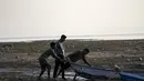 Nelayan mendorong perahu ke perairan di lahan basah Bendungan Pong di Nagrota Suriyan, sekitar 65 kilometer (40 mil) selatan Dharmsala, India, Senin (14/2/2022). Lahan Basah Pong menampung dan mendukung ratusan burung yang bermigrasi spesies di bulan-bulan musim dingin. (AP Photo/Ashwini Bhatia)