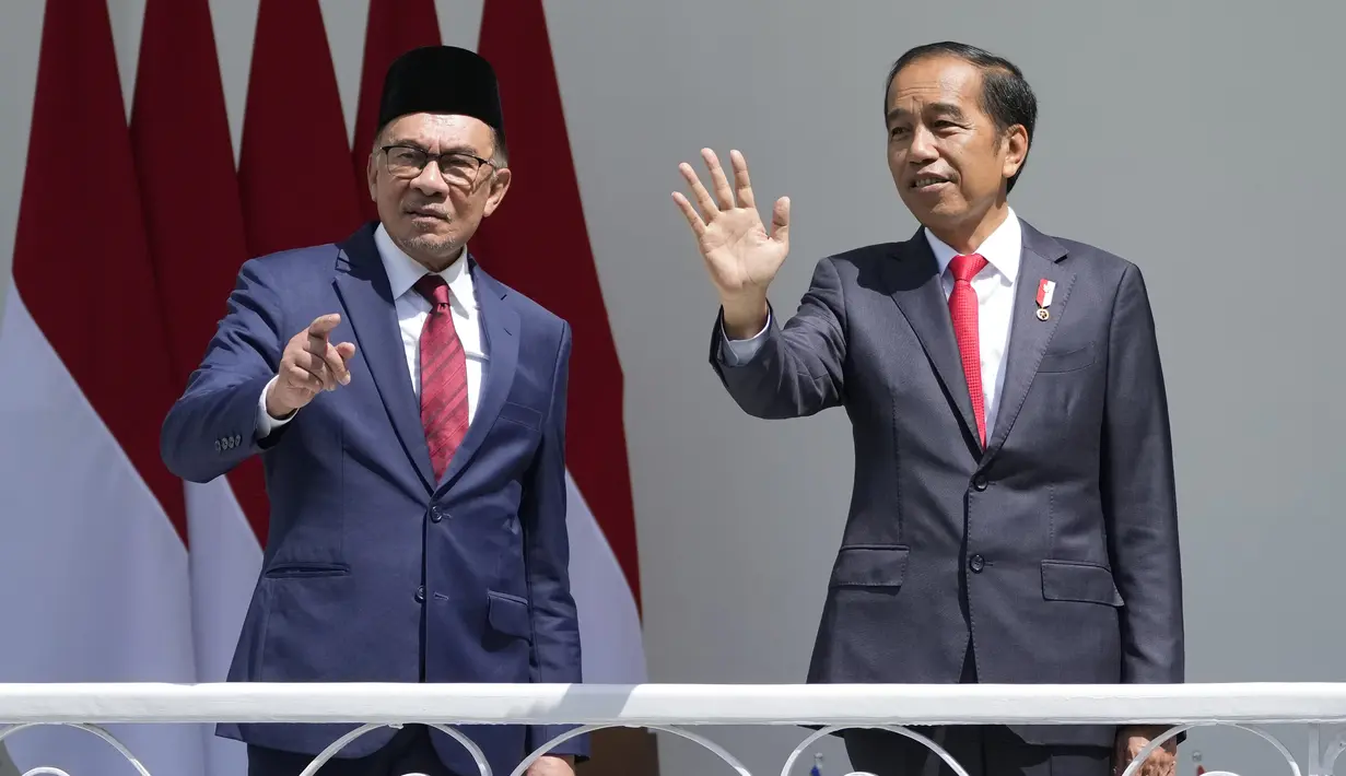 Presiden Joko Widodo (kanan) bersama  Perdana Menteri Malaysia Anwar Ibrahim melambaikan tangan di veranda Istana Kepresidenan Bogor, Jawa Barat, Senin (9/1/2023). Presiden Joko Widodo menerima kunjungan kenegaraan Perdana Menteri Malaysia Anwar Ibrahim di Istana Bogor. (AP Photo/Achmad Ibrahim)