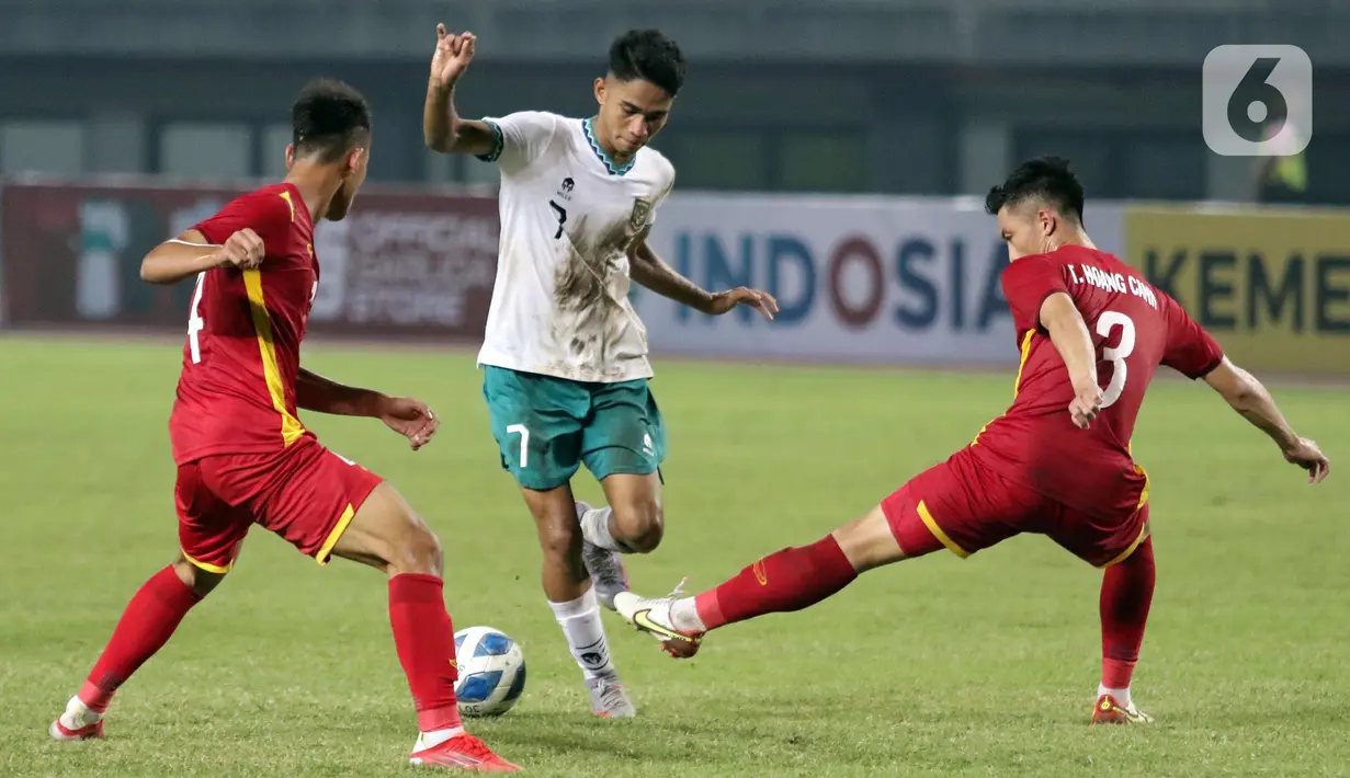 Pemain tengah Timnas Indonesia U-19, Marselino Ferdinan (tengah) berusaha melewati dua pemain Vietnam U-19 pada kualifikasi grup A Piala AFF U-19 2022 di Stadion Patriot Candrabhaga, Bekasi, Jawa Barat, Sabtu (2/7/2022). Laga kedua tim berlangsung ketat, saling adu serangan dan berusaha menampilkan permainan terbaik. (Liputan6.com/Helmi Fithriansyah)
