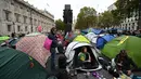 Para aktivis iklim duduk dalam tenda saat mereka berkemah di Westminster, London, Inggris, Selasa (8/10/2019). Protes para aktivis iklim ini telah mengganggu aktivitas warga  kota. (Ben STANSALL/AFP)