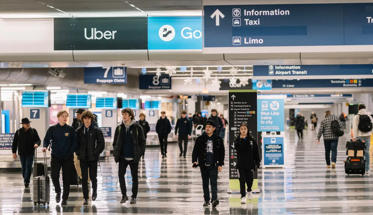 Para pelancong berjalan melalui pengambilan bagasi di Bandara O'Hare pada tanggal 12 Januari 2024 di Chicago, Illinois. (Jim Vondruska/Getty Images via AFP)