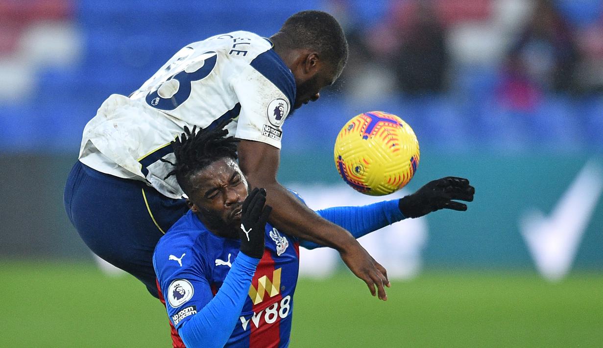 Gelandang Tottenham Hotspur, Tanguy Ndombele (atas), berduel udara dengan gelandang Crystal Palace, Jeffrey Schlupp dalam laga lanjutan Liga Inggris 2020/21 pekan ke-12 di Selhurst Park Stadium, Minggu (13/12/2020). Tottenham bermain imbang 1-1 dengan Palace. (AFP/Glyn Kirk/Pool)