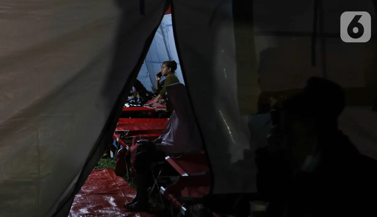 Warga terdampak gempa saat mengungsi di posko pengungsian di Taman Prawatasari, Kabupaten Cianjur, Jawa Barat, Selasa (22/11/2022). Gubernur Jawa Barat Ridwan Kamil menyebut, sebanyak 14 posko pengungsian didirikan untuk memfasilitasi warga berjumlah 13.784 pengungsi yang terdampak gempa berkekuatan 5,6 SR di Kabupaten Cianjur. (Liputan6.com/Herman Zakharia)