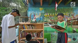 Anak-anak membaca buku di Saung Pustaka Air di Depok, Jawa Barat, (30/5). Perpustakaan ini menjadi sarana edukasi untuk menjaga dan mengenalkan area konservasi keanekaragaman hayati. (Liputan6.com/Herman Zakharia)