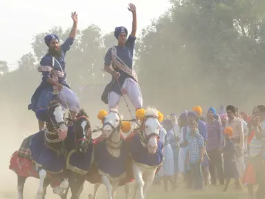 Sikh India 'Nihangs', atau anggota militer tradisional Sikh menujukkan keterampilan berkuda selama perayaan Fateh Divas di Amritsar (20/10). Perayaan Fateh Divas ini digelar sehari setelah festival Diwali. (AFP/Narinder Nanu)