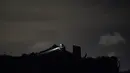 Cody Scott mencari barang-barang di loteng setelah tornado merobek atap rumah ayah mertuanya, di Arabi, La., Selasa (22/3/2022). Tornado menerjang bagian New Orleans dan sekitarnya Selasa malam, menghancurkan kabel listrik dan menyebarkan puing-puing di bagian kota. (AP Photo/Gerald Herbert)