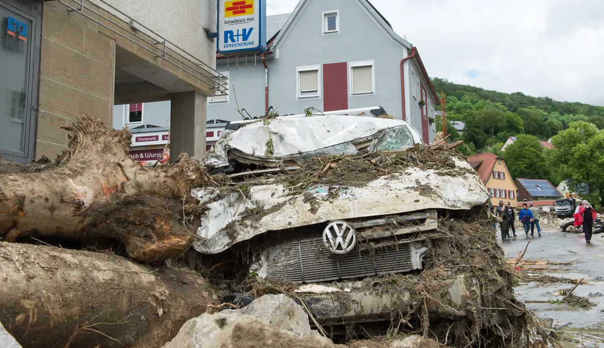 Mobil yang rusak disertai batang pohon yang terbawa oleh aliran arus banjir yang melanda wilayah Braunsbach, Jerman selatan (30/5). Empat orang tewas dan beberapa lainnya luka-luka dalam musibah ini. (Marijan Murat / dpa / AFP)