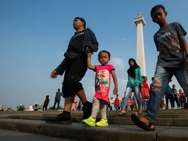Sejumlah pengunjung berjalan-jalan di kawasan Monumen Nasional (Monas) Jakarta, Kamis (6/6/2019). Monas yang merupakan Ikon Ibu Kota itu menjadi salah satu tujuan wisata untuk mengisi libur Lebaran. (merdeka.com/Imam Buhori)