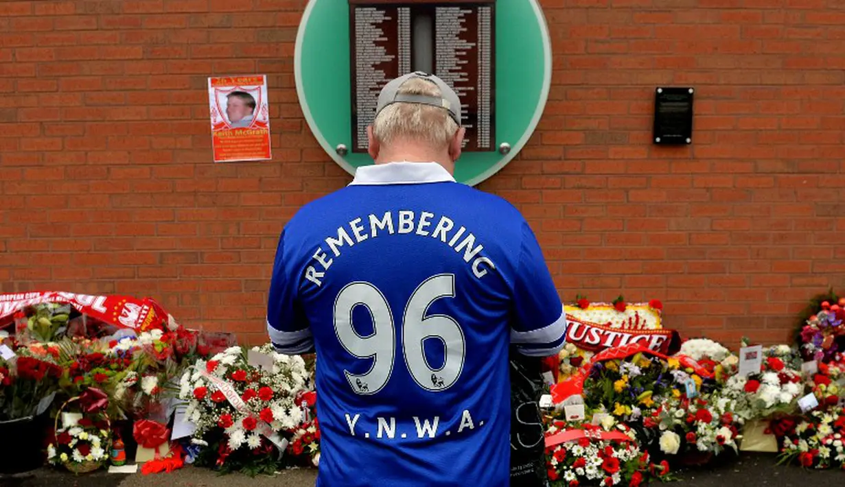 1.	Seorang suporter Everton berdoa di depan dinding bertuliskan daftar korban Tragedi Hillsborough saat peringatan 26 tahun Tragedi Hillsborough di Stadion Anfield