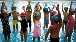Anak-anak melakukan pemanasan sebelum latihan berenang di sekolah olahraga Hangzhou Chen Jinglun Natatorium, di Hangzhou, provinsi Zhejiang, China, (10/8). (REUTERS/Aly Song)