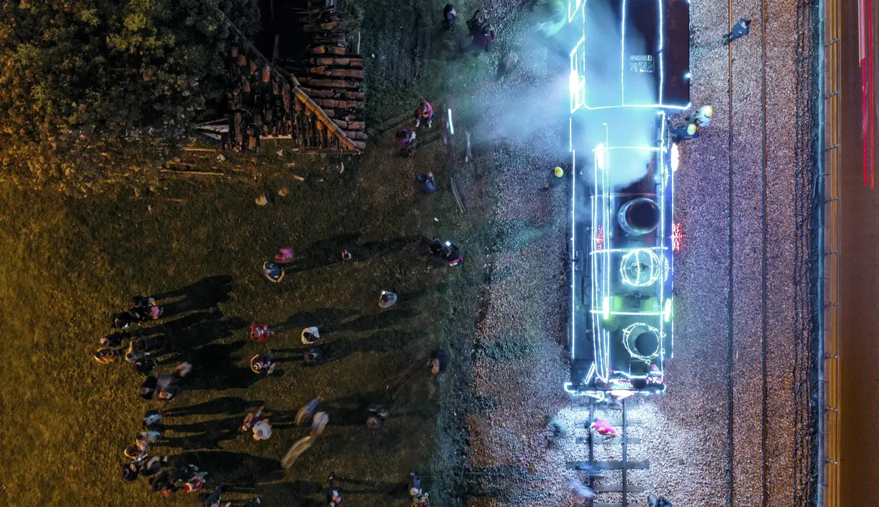 Foto udara kereta wisata yang dihiasi lampu Natal di Bogota (20/12/2019). Meyambut Hari Natal, kereta wisata di Kolombia membuat cara unik dengan memasangkan lampu warna-warni agar menjadi daya tarik penumpang. (AFP Photo/Guillermo Munoz)