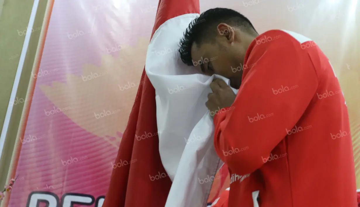 Anggota Tim Thomas Indonesia, Tommy Sugiarto, mencium bendera merah putih saat acara pelepasan tim Thomas-Uber Indonesia di Pelatnas Bulutangkis PBSI, Cipayung, Jakarta, (9/5/2016). (Bola.com/Arief Bagus)