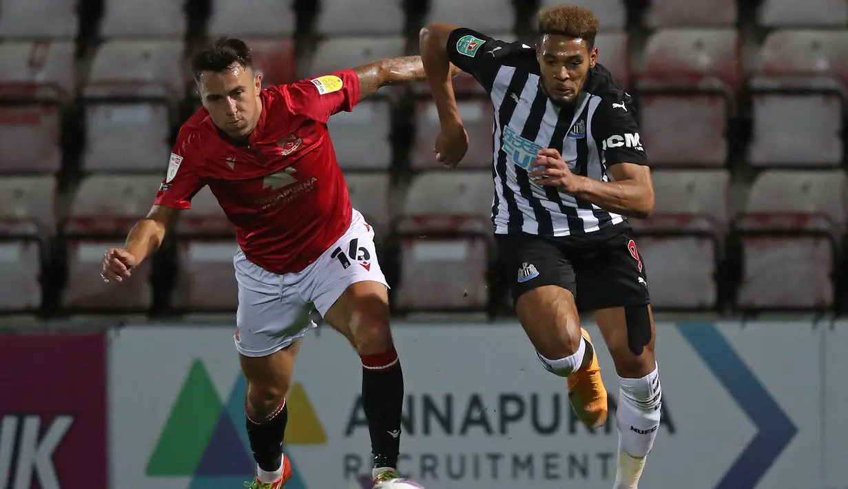 Striker Newcastle, Joelinton, berebut bola dengan gelandang Morecambe, John O'Sullivan, pada laga putaran ketiga Piala Liga Inggris di The Mazuma Stadium, Kamis (24/9/2020) dini hari WIB. Newcastle menang 7-0 atas Morecambe. (AFP/Martin Rickett/pool)