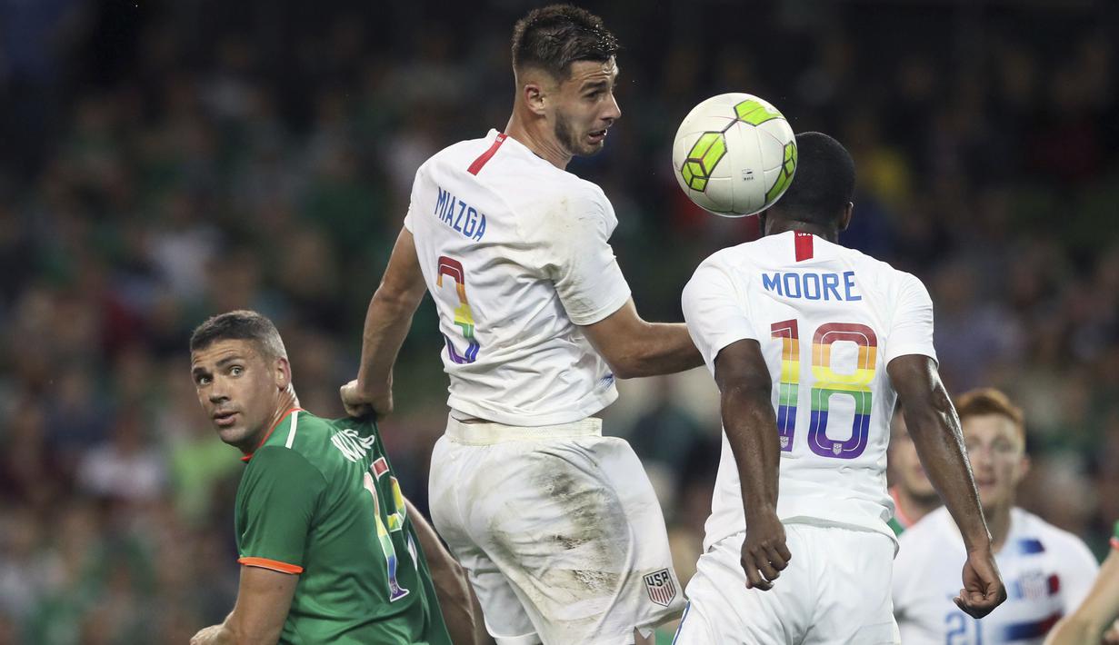 Pemain Amerika Serikat, Matt Miazga (tengah) membuang bola dari kejaran pemain Irlandia pada laga uji coba di Aviva Stadium, Dublin, (2/6/2018). Irlandia menang 2-1. (Brian Lawless/PA via AP)