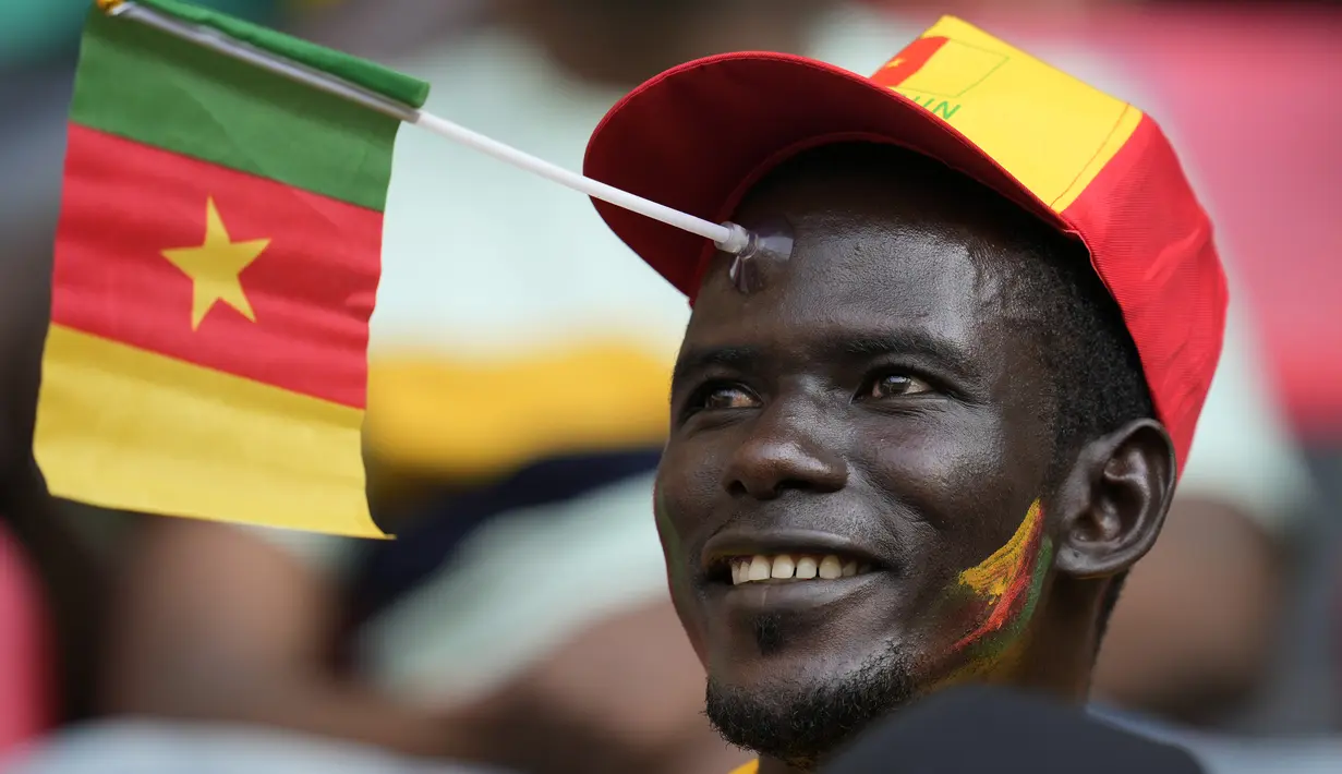 Seorang Suporter Kamerun tersenyum sebelum dimulainya pertandingan sepak bola grup A Piala Afrika 2021 antara Kamerun melawan Burkina Faso di stadion Olembe di Yaounde, Minggu, (9/1/2022). Kamerun untuk kali kedua menjadi tuan rumah Piala Afrika setelah pada 1972. (AP Photo/Themba Hadebe)
