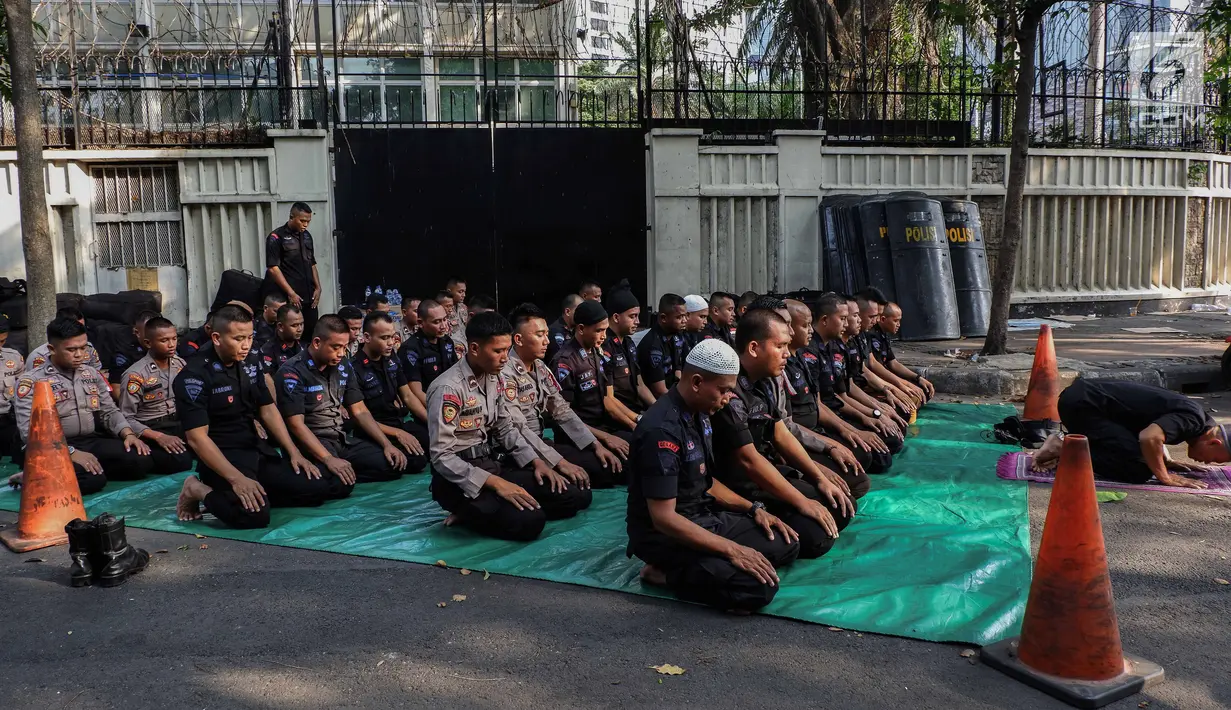 Pasukan Brimob menunaikan ibadah salat Ashar berjamaah disela pengamanan di kawasan Bundaran HI, Jakarta, Rabu (29/5/2019). Di tengah tugas mengamankan situasi, para anggota Brimob tak lupa untuk tetap menjalankan kewajibannya sebagai umat beragama. (Liputan6.com/Faizal Fanani)