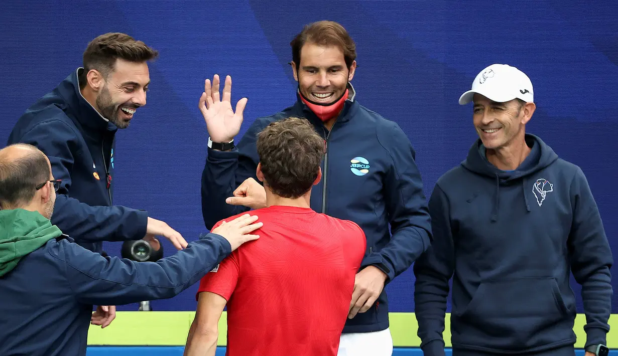 Petenis Spanyol, Rafael Nadal (tengah) memberi selamat kepada rekannya, Pablo Carreno Busta usai mengalahkan petenis Australia, John Millman dalam Turnamen Tenis ATP Cup di Melbourne, Selasa (2/2/2021). Spanyol menang 3-0 atas Australia. (AFP/David Gray)