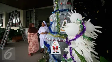 Seorang suster saat menjelaskan kepada pengunjung tentang pohon Natal dari limbah medis di RS Panti Nugroho, Sleman, Rabu (23/12). Ratusan infus, sarung tangan dan masker bekas pakai yang telah disterilkan dirangkai menjadi pohon Natal. (Boy Harjanto)