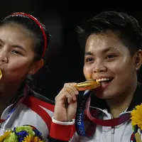 Ganda putri Indonesia Greysia Polii / Apriyani Rahayu berpose dengan medali emas badminton Olimpiade Tokyo 2020 di Musashino Forest Sports Plaza, Tokyo, Jepang, Senin, 2 Agustus 2021. (Alexander NEMENOV / AFP)