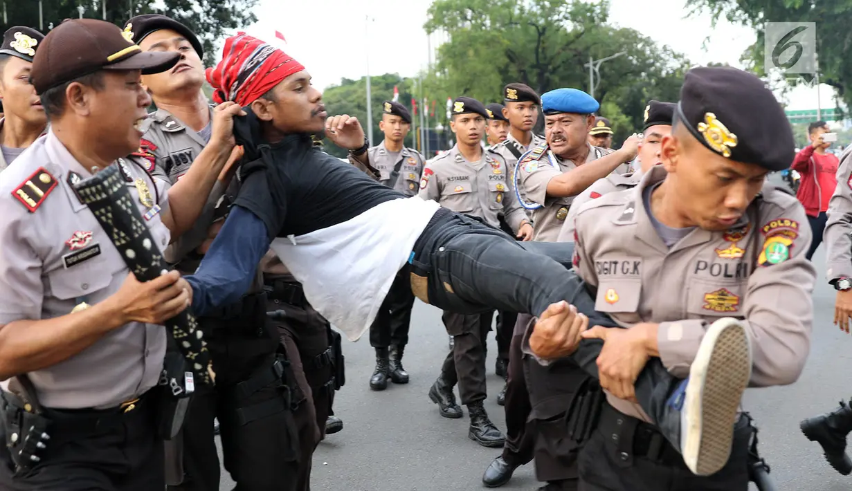 Petugas kepolisian mengamankan mahasiswa yang melakukan unjuk rasa di depan Istana Negara, Kamis (18/5). Kericuhan terjadi karena polisi memaksa untuk membubarkan massa aksi yang dinilai tidak koperatif. (Liputan6.com/Immanuel Antonius)