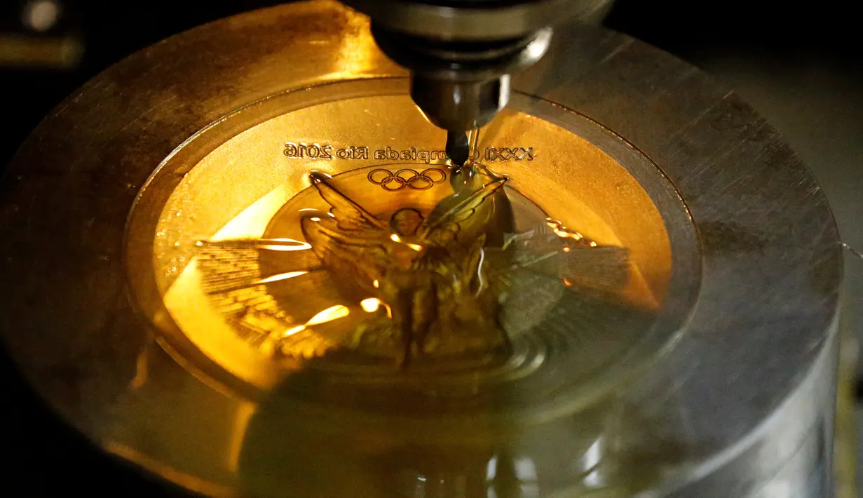 Sebuah mesin membuat ukiran pada bagian medali untuk Olimpiade Rio 2016 di Casa da Moeda do Brasil (Brazilian Mint), Rio de Janeiro, Brasil, (28/6). Sekitar 5.130 medali akan diselesaikan dalam waktu dua hari. (REUTERS/Sergio Moraes)