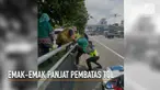 Diturunkan di pinggir tol, emak-emak ini dibantu polisi untuk memanjat pembatas tol yang tinggi.