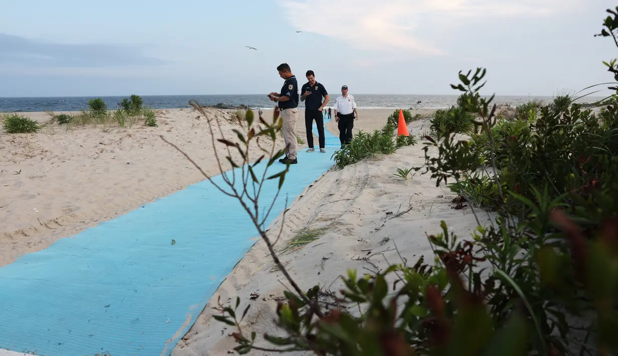 Polisi berkumpul di sepanjang Rockaway Beach di 59th Street setelah seorang wanita diserang oleh hiu pada sore hari tanggal 7 Agustus 2023 di New York City. (Spencer Platt/Getty Images/AFP)