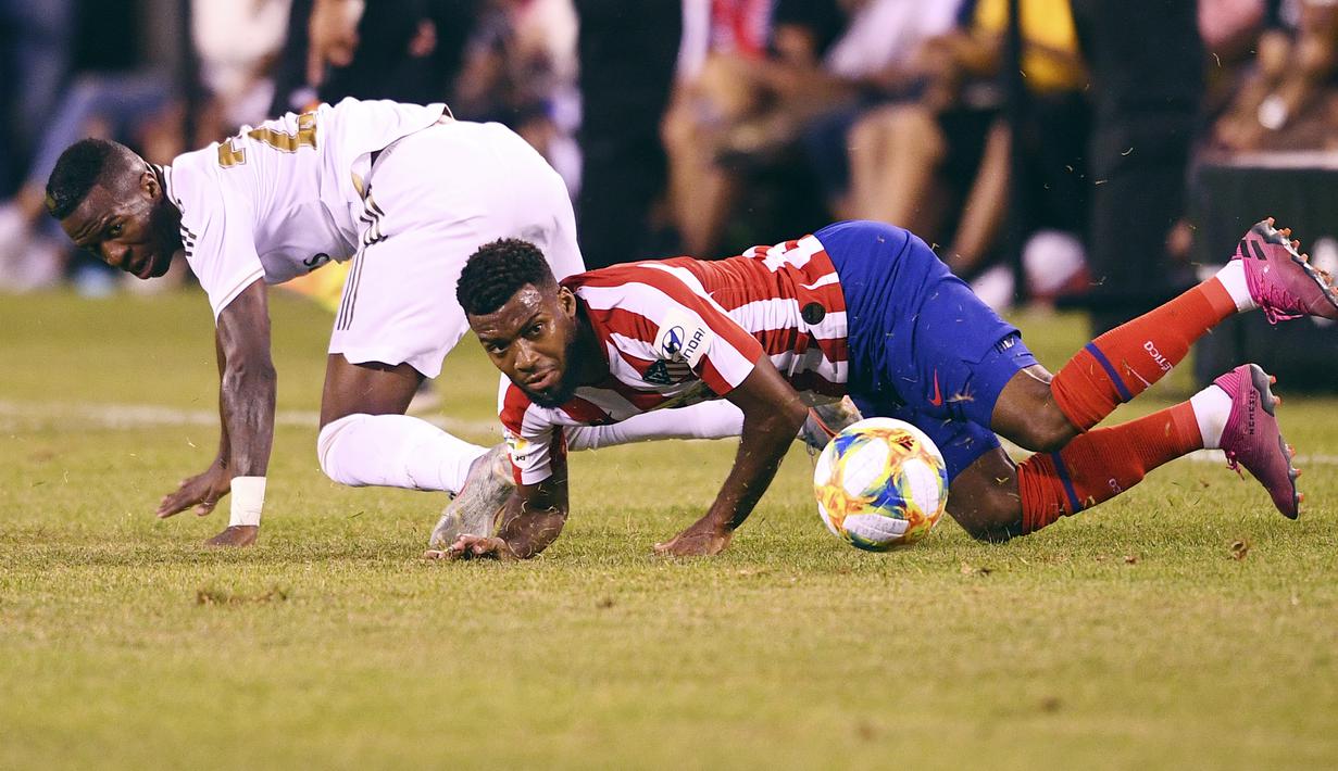 Penyerang Real Madrid, Vinicius Junior berebut bola dengan gelandang Atletico Madrid, Thomas selama laga International Champions Cup 2019 di Arena Stadium Metlife, New Jersey (27/7/2019). Atletico menang telak 7-3 atas Real Madrid. (AFP Photo/Johannes Eisele)