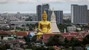 <p>Patung Buddha raksasa setinggi 69 meter berdiri di kuil Wat Paknam Phasi Charoen di pinggiran Bangkok, Thailand pada Selasa (12/10/2021). Patung raksasa yang mulai dibangun tahun 2017 dan ukurannya setinggi gedung 20 lantai ini menghiasi langit kota metropolitan Bangkok. (Jack TAYLOR / AFP)</p>