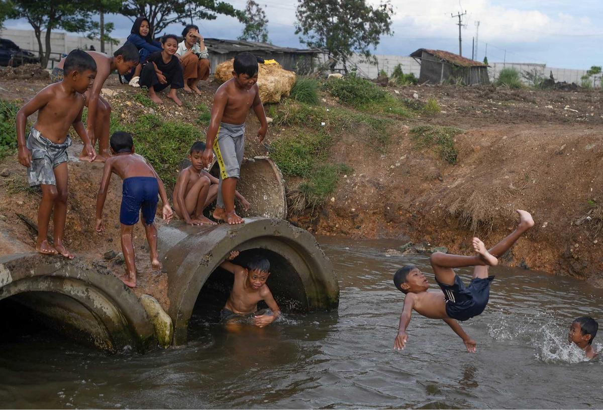 FOTO: Keceriaan Anak-Anak Bermain Pada Saluran Air di Tanjung Pasir