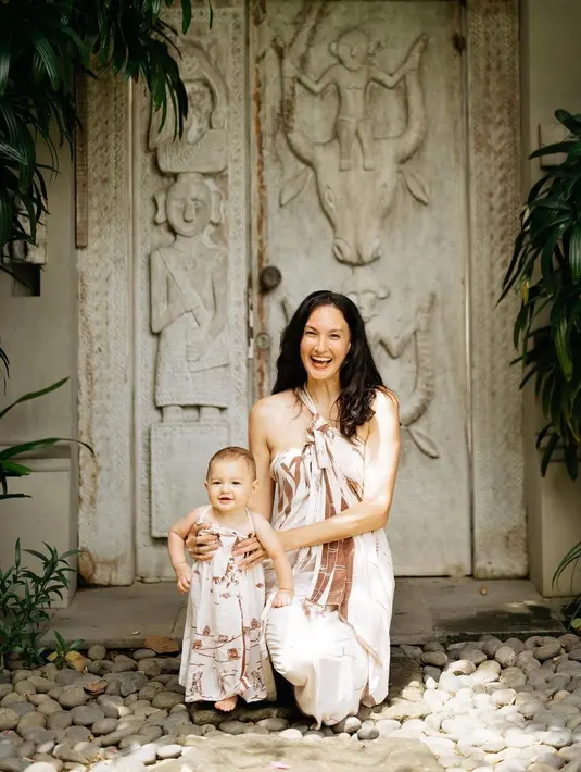 Kebersamaan gemas lainnya dari Nadine dan sang buah hati. Di halaman rumput, Nadine tampak sedang bermain dengan sang buah hati mengenakan halter-neck dress bermotif, sedangkan sang buah hati sendiri tampak mengenakan dress pendek yang serasi dengan sepatu dan hiasan kepalanya. Foto: Instagram.