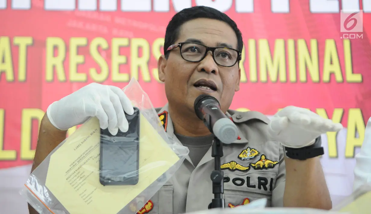 Kabid Humas Polda Metro Jaya Kombes Pol Argo Yuwono menunjukkan barang bukti kasus penjambretan di Polda Metro Jaya, Jakarta, Senin (8/4). Polisi mengungkap kasus penjambretan di Jalan HR Rasuna Said yang mengakibatkan penumpang ojol tewas. (Liputan6.com/Herman Zakharia)