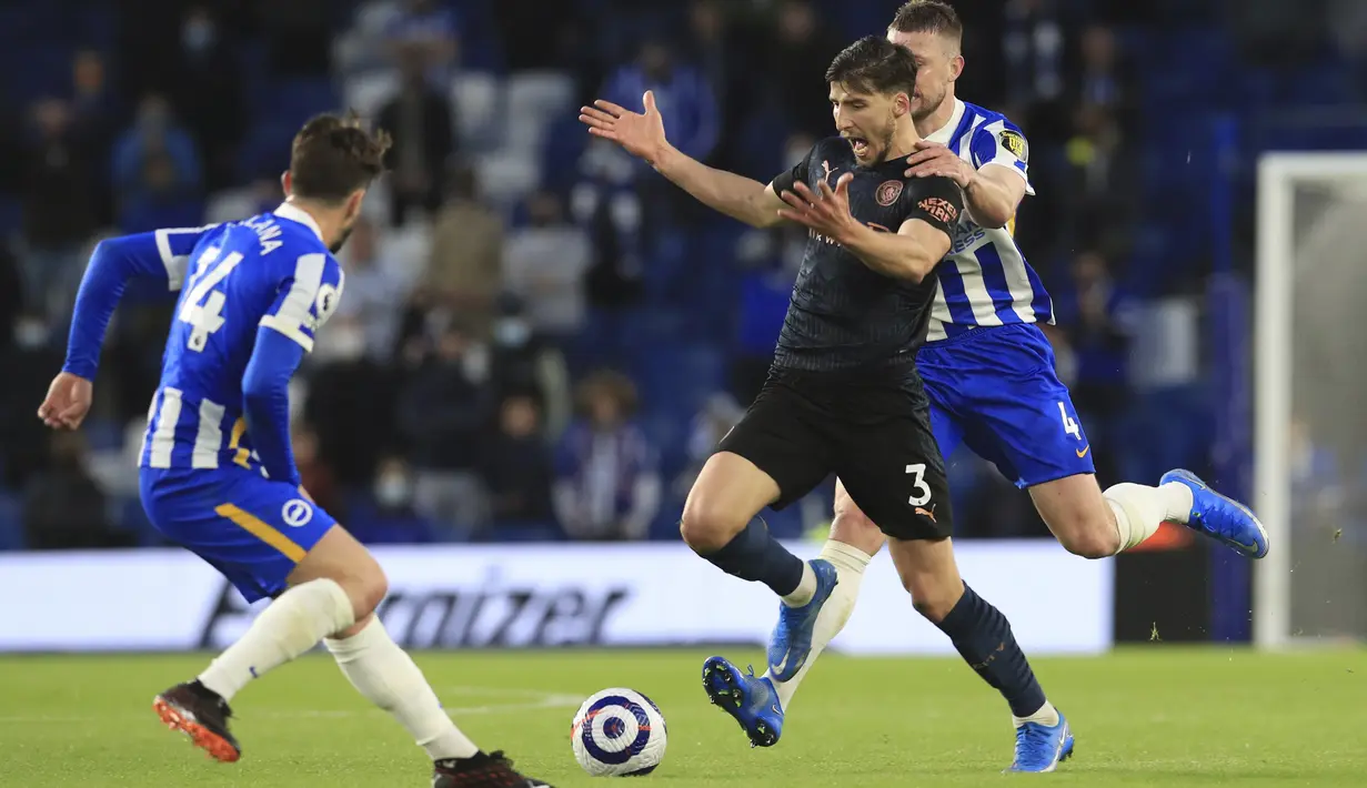 Bek Manchester City, Ruben Dias bersaing dengan bek Brighton and Hove Albion, Adam Webster pada pekan 37 Liga Inggris di Amex Stadium, Rabu (19/5/2021) dinihari WIB. Manchester City yang sudah dipastikan menjuarai Liga Inggris kalah dramatis saat dijamu Brighton, 2-3. (Gareth Fuller, Pool via AP)