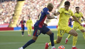 Pemain Barcelona, Lamine Yamal (kiri), berupaya melewati adangan bek Villarreal, Sergi Cardona, pada pekan 37 Liga Spanyol 2024/2025 di Lluis Companys Olympic Stadium, Senin (19/5/2025) dini hari WIB. (AP Photo/Joan Monfort)