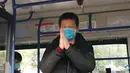 Seorang pasien virus corona yang telah pulih memberi salam kepada para pekerja medis dari dalam bus setelah meninggalkan rumah sakit sementara Wuchang di Wuhan, Provinsi Hubei, China tengah (10/3/2020). (Xinhua/Wang Yuguo)