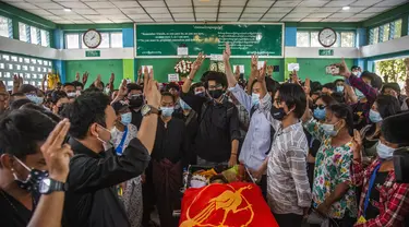 Orang-orang memberi hormat tiga jari selama pemakaman Khant Ngar Hein di Yangon, Myanmar, Selasa (16/3/2021).  Khant Ngar Hein, seorang mahasiswa kedokteran berusia 18 tahun ditembak di dadanya pada hari Minggu, 14 Maret di Tamwe, Yangon oleh pasukan keamanan selama protes anti-militer. (AP Photo)
