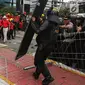 Pewarta foto mengamati pagar besi di pelican crossing Tosari yang roboh saat peringatan Hari Buruh 2019 di kawasan Sudirman dekat Bundaran HI, Jakarta, Rabu (1/5/2019). Pagar itu roboh terimbas aksi dorong buruh dan polisi yang menahan agar massa tidak menuju Bundaran HI. (Liputan6.com/Johan Tallo)