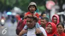 Pendukung Timnas Indonesia membopong anak saat berjalan menuju Stadion Pakansari, Bogor (3/12). Timnas Indonesia akan melakoni laga semifinal pertama Piala AFF 2016 melawan Vietnam di Stadion Pakansari Kab Bogor. (Liputan6.com/Helmi Fithriansyah)