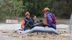 Petugas pemadam kebakaran dengan perahu karet mengevakuasi orang-orang dan hewan peliharaan dari sebuah bangunan yang terendam banjir di Larissa, Yunani Tengah, Rabu, 6 September 2023. (AP Photo/Vaggelis Kousioras)