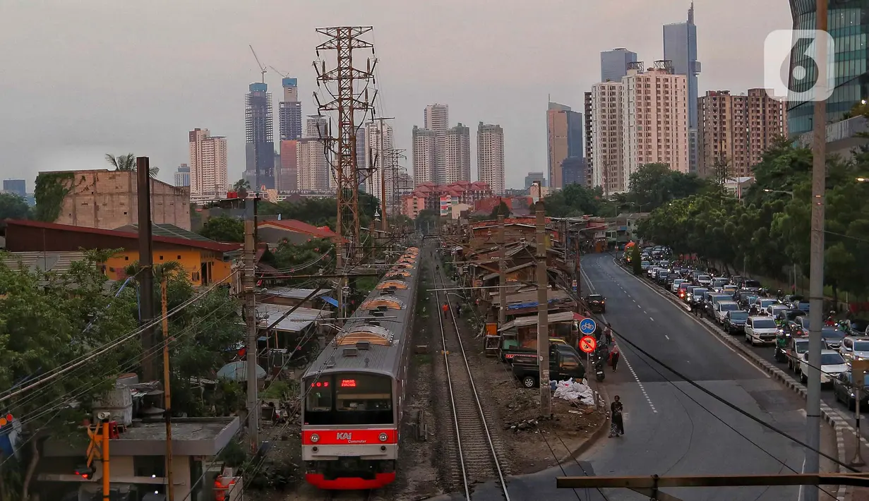 Kondisi pemukiman di pinggir rel kereta dengan latar gedung bertingkat di Jakarta, Jumat (15/12/2023). (Liputan6.com/Angga Yuniar)